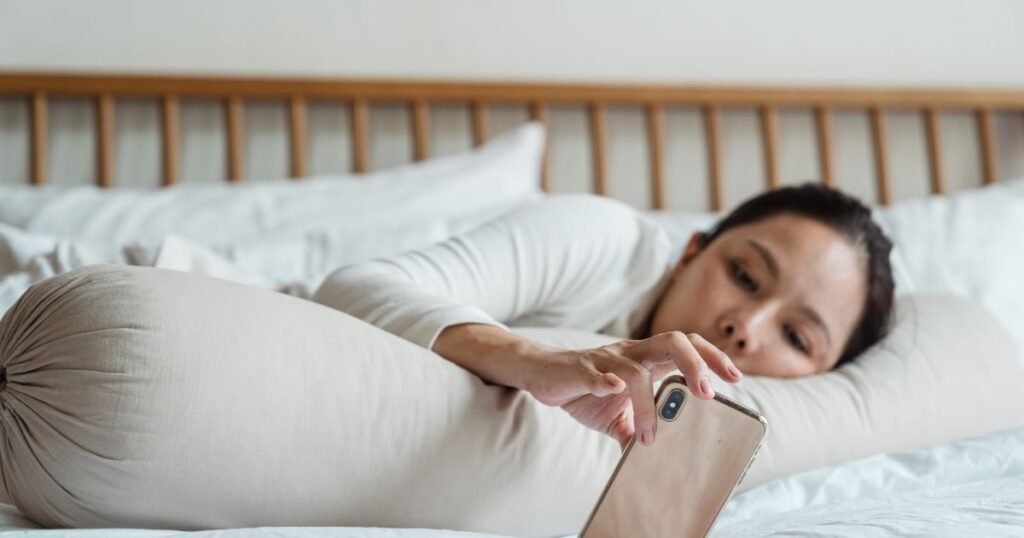 women in bed on phone